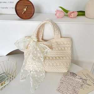Detailed view of cream lace crochet tote bag featuring a large decorative lace bow