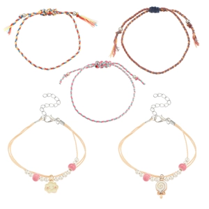 Close-up of bohemian handmade woven friendship bracelets with cloud and candy charms