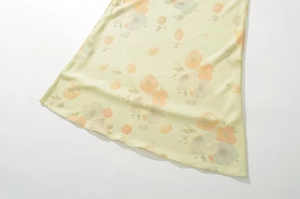 Détail de l'ourlet de robe en mousseline jaune clair avec imprimé floral orange
