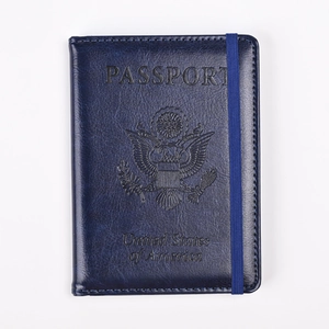 Detalle de funda de pasaporte azul oscuro en cuero PU con sello grabado y elástico