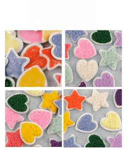 Macro shot of colorful chenille heart and star patches with detailed embroidery