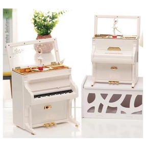 Detail of white upright piano music box showing rotating ballerina and interior rose motif