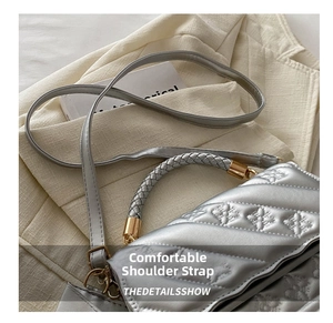 Detail of silver embossed crossbody bag with diagonal quilting and gold-tone hardware