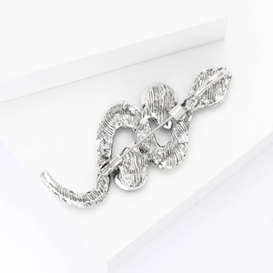 Detailed close-up of a silver snake brooch with intricate scale texture and back pin