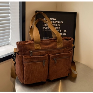 Detail of caramel corduroy tote bag with dual front zipper pockets and strap