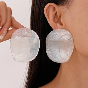 Minimalist white resin irregular round stud earrings worn by model for elegant style