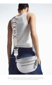Detail of silver metallic waist bag with geometric woven strap on female model