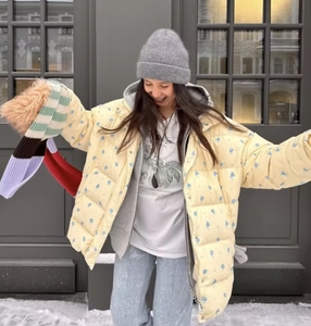 Detail of yellow floral hooded puffer jacket with grey knit beanie and multicolor scarf