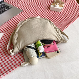 Interior view of beige nylon crescent bag showing high capacity for daily essentials