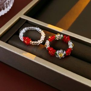 Detail of handmade colorful beaded flower rings displayed in a luxury jewelry box