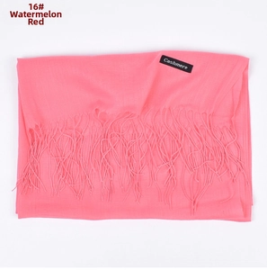Detail of watermelon red cashmere scarf featuring soft fringes and authentic brand label