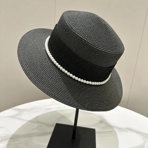 Detail of black straw boater hat with pleated ribbon and pearl trim for sun protection