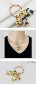Detail of gold plated necklace pendant with colorful cubic zirconia charms and motifs