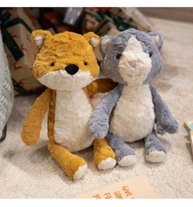 Detail of plush fox and cat toys with curly sherpa fleece on a soft carpet background