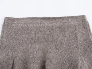 Detail of grey knitted skirt waist showing elastic waistband and thick woolen texture