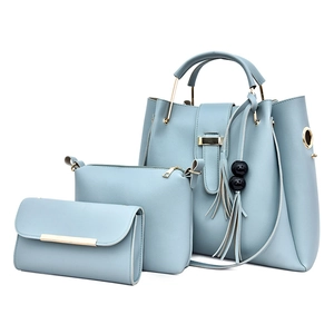 Three-piece light blue faux leather handbag set with tote, crossbody bag, and tassel