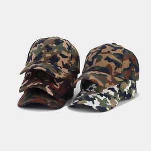 Detailed view of camouflage corduroy fabric texture and curved brim on baseball caps