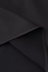 Dettaglio della trama del tessuto nero e delle cuciture professionali del vestito