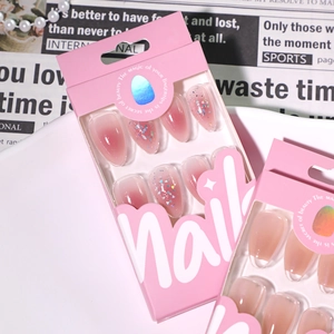 Short almond press-on nails with pink glitter gradient and heart sequins in a gift box