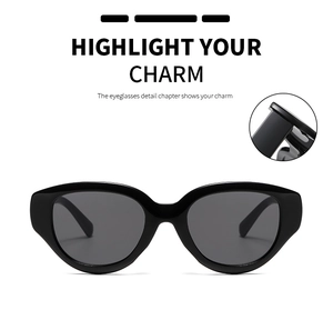 Close-up of black oversized cat-eye sunglasses with thick frame and metal hinge details