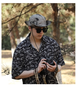 Outdoor camouflage sun hat with wide brim and chin strap worn in nature settings