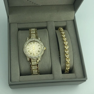 Detailed view of women's gold-tone rhinestone watch and matching heart bracelet in a gift box