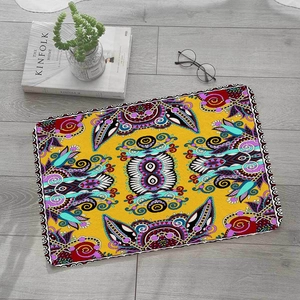 Square bohemian yellow flannel absorbent mat with ethnic patterns on grey wood floor