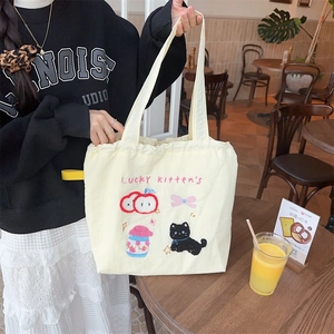 Detail of cute puppy embroidery and Lucky Kitten's text on cream canvas tote bag