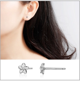 Macro detail of S999 sterling silver flower stud earrings with matte petal texture and hallmark