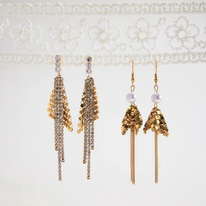 Detail of 18K gold stainless steel fringe earrings with white zircon and pearls on lace