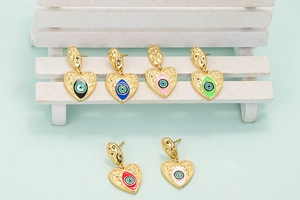 Macro shot of colorful enamel heart evil eye earrings with hammer-textured 18K gold finish