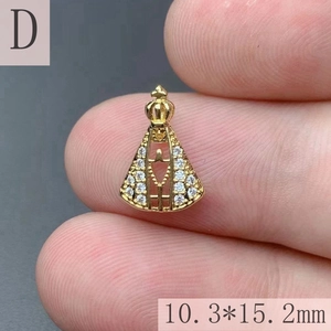 Macro detail of 18K gold plated crown Virgin Mary pendant with white rhinestones