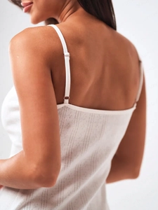 Detail of white floral sundress with adjustable straps and delicate lace texture