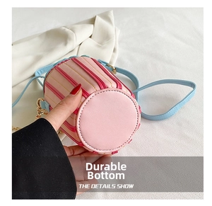 Detail of pink and red striped cylinder bag showing wear-resistant round leather base