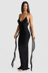 Détail de robe de soirée noire avec col en V, bustier à volants et rubans élégants
