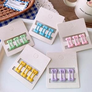 Detailed set of bone-shaped hair clips in five matte macaron colors on display cards