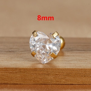 Macro shot of an 8mm heart-shaped zircon earring with a gold-tone four-prong setting