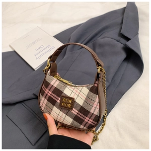 Détail du mini sac croissant à carreaux avec garniture en cuir et bandoulière dorée