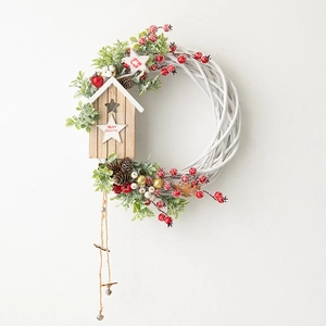 White woven Christmas wreath with red berries, pine cones and a wooden birdhouse