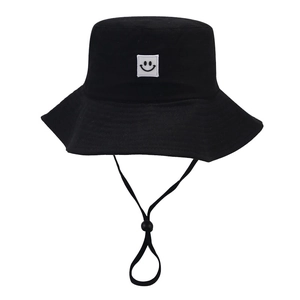 Black wide brim bucket hat with smiley patch and adjustable wind rope for outdoor sun protection