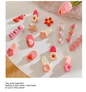 Detailed flat lay of cute pink Y2K hair clips with resin flowers and hearts for girls