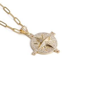 Collana con ciondolo a bussola hip hop dorata con zirconi micro pavé su fondo bianco