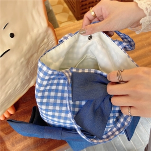 Internal view of blue gingham tote bag showing inner pocket and metal snap closure