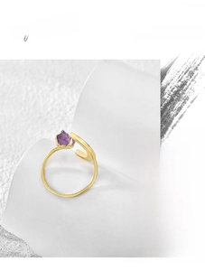 Macro detail of raw amethyst stone set in a minimalist gold-plated open moon ring