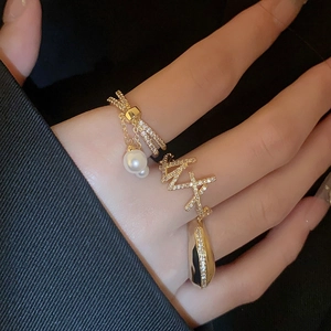 Detail of three-piece 18K gold plated ring set with zircon, pearls and bow-knot design