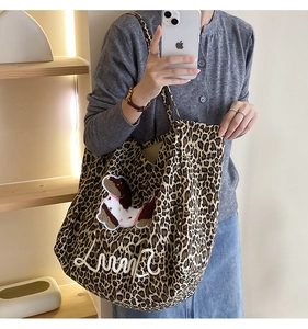 Detail of leopard print canvas tote bag featuring Lumpy embroidery and cartoon patch