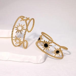 Detail of vintage gold starburst bangles with black and white enamel inlays