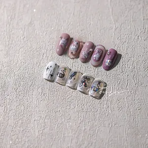 Detail of pink and silver luxury press-on nails with 3D pearls and swan motifs