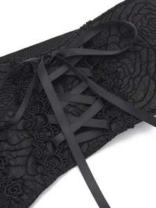 Detail of black floral lace waist belt featuring intricate patterns and satin ribbon ties