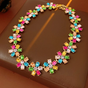 Detail shot of vintage golden flower necklace with colorful gemstones on brown leather